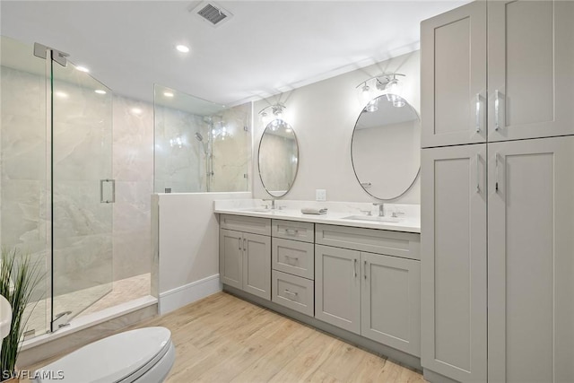 bathroom with wood-type flooring, vanity, toilet, and walk in shower