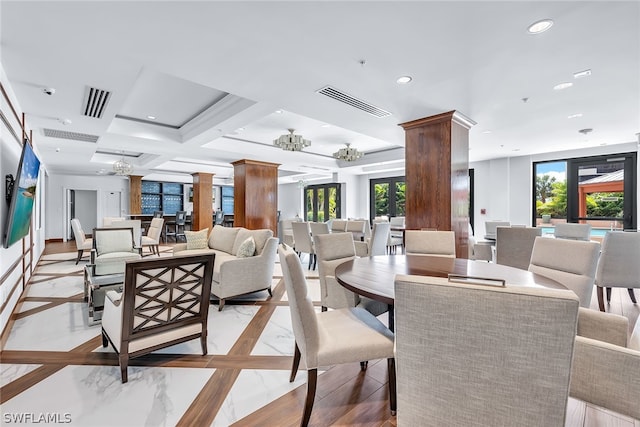 dining area with coffered ceiling, ornate columns, french doors, and a chandelier