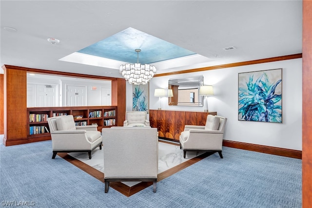 living room with ornamental molding, a tray ceiling, and a notable chandelier