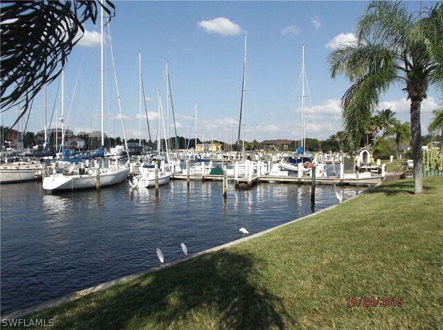 view of dock with a water view and a lawn