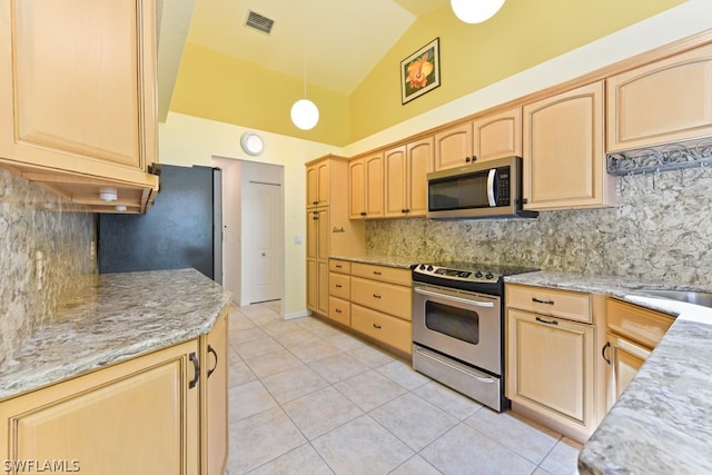 kitchen featuring backsplash, light tile flooring, lofted ceiling, stainless steel appliances, and light stone countertops