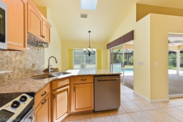 kitchen featuring sink, lofted ceiling, a wealth of natural light, light tile floors, and stainless steel dishwasher