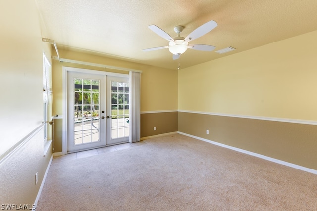 carpeted empty room with french doors, ceiling fan, and a textured ceiling