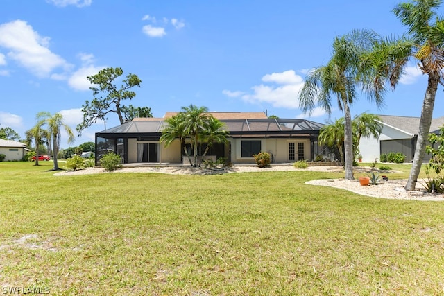 rear view of property with glass enclosure and a lawn