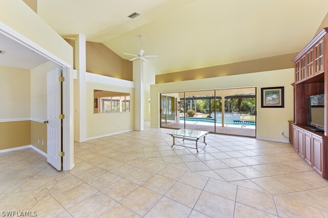 unfurnished living room with high vaulted ceiling, ceiling fan, and light tile floors