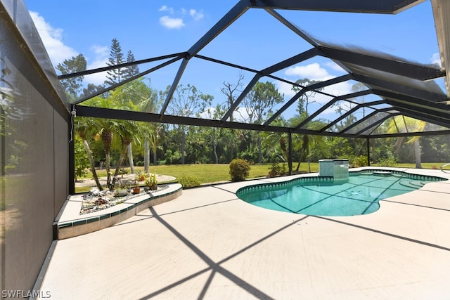 view of pool with a patio, a lawn, and glass enclosure