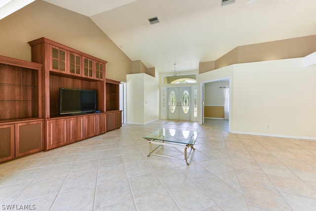 unfurnished living room featuring high vaulted ceiling and light tile floors