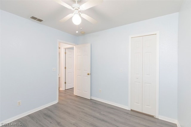 unfurnished bedroom featuring ceiling fan, light hardwood / wood-style flooring, and a closet