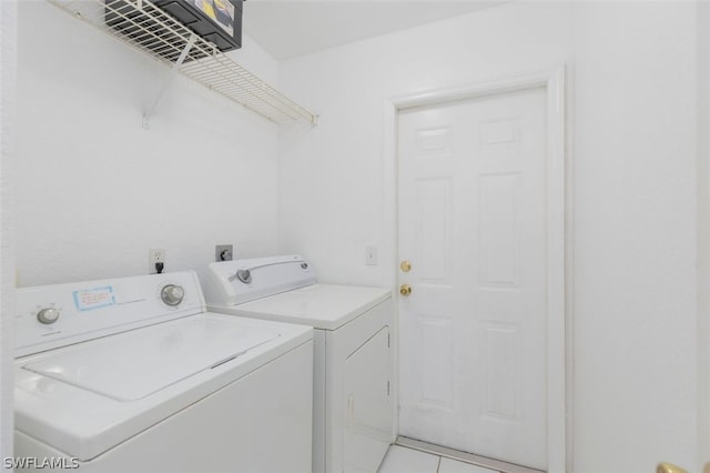 washroom with independent washer and dryer and light tile patterned flooring