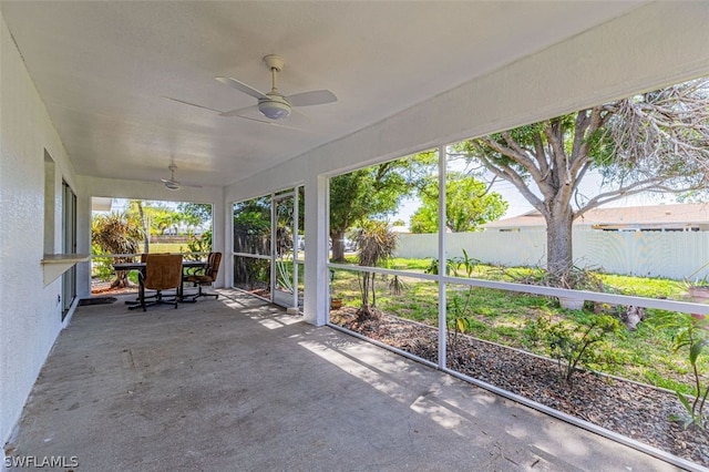 unfurnished sunroom featuring ceiling fan