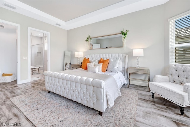 bedroom featuring hardwood / wood-style flooring and ensuite bathroom