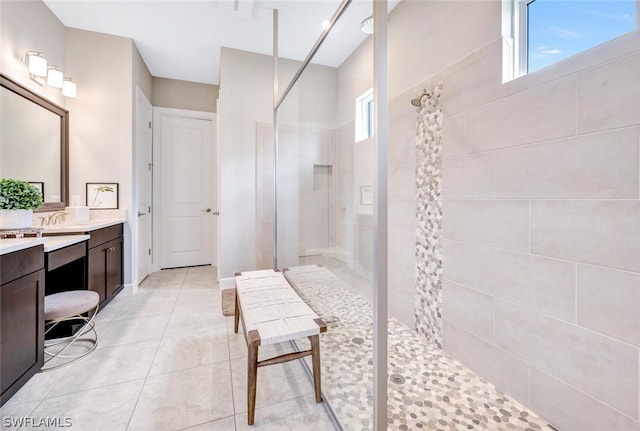 bathroom featuring tiled shower, vanity, and tile floors