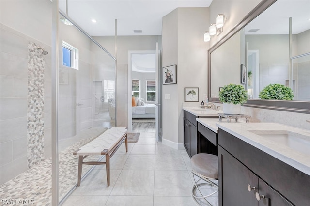 bathroom with tile flooring, dual sinks, a tile shower, and large vanity