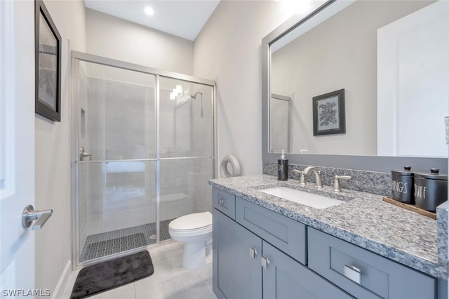 bathroom featuring tile flooring, walk in shower, oversized vanity, and toilet