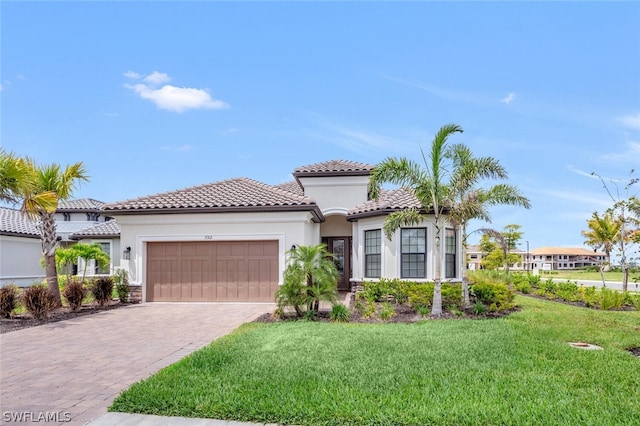 mediterranean / spanish home with a garage and a front yard