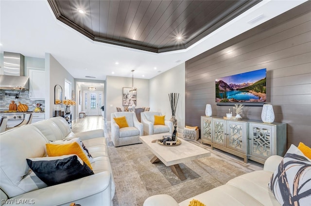 living room featuring light hardwood / wood-style floors and a tray ceiling