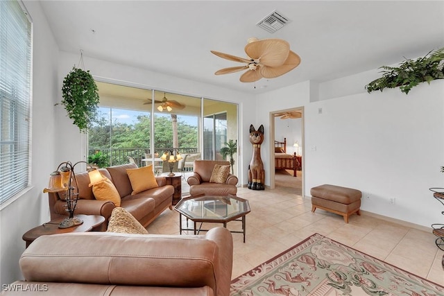 living room featuring light tile patterned flooring, ceiling fan, and a wealth of natural light