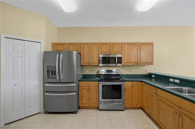 kitchen with stainless steel appliances, sink, and light tile floors