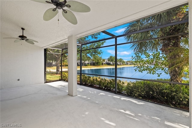 unfurnished sunroom with a water view and ceiling fan