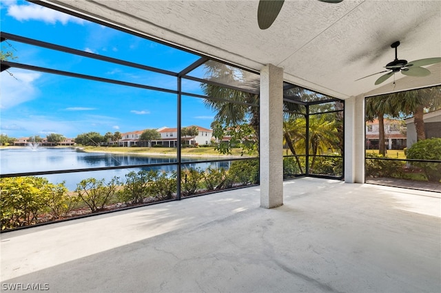 unfurnished sunroom featuring a water view and ceiling fan