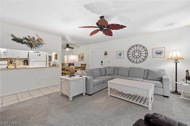 carpeted living room with sink and ceiling fan