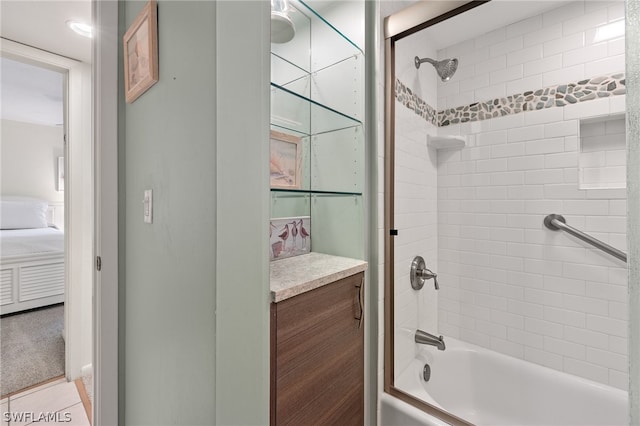 bathroom featuring tiled shower / bath, tile flooring, and vanity