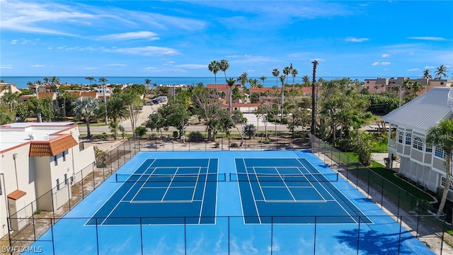 view of tennis court with a water view