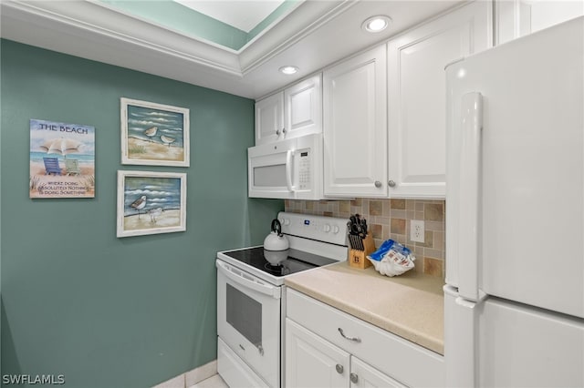 kitchen with white appliances, white cabinetry, and backsplash