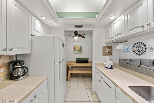 kitchen featuring white appliances, backsplash, ceiling fan, and a raised ceiling