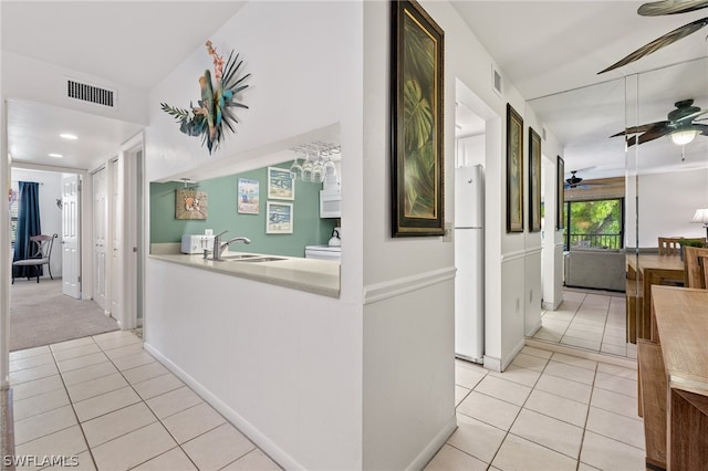 corridor with sink and light tile flooring