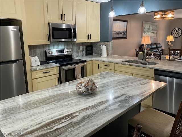 kitchen featuring decorative backsplash, sink, stainless steel appliances, and cream cabinetry