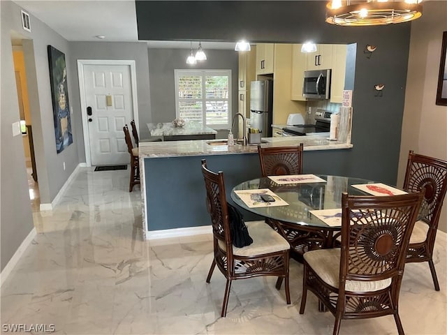 dining space with a notable chandelier and sink