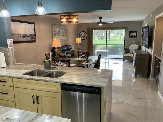 kitchen with light stone countertops, dishwasher, sink, cream cabinets, and pendant lighting