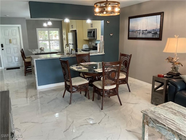 dining area with a chandelier and sink