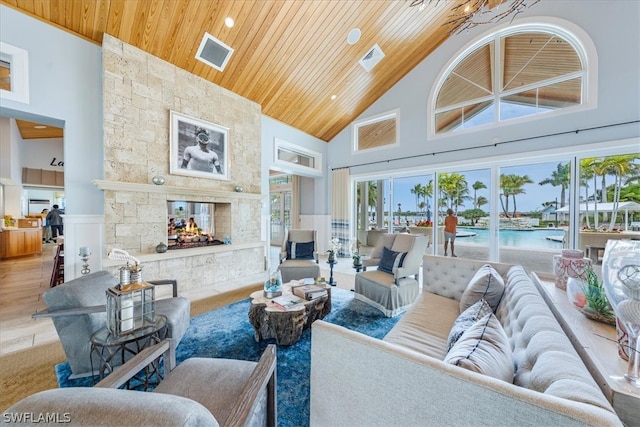 living room featuring wooden ceiling, hardwood / wood-style flooring, high vaulted ceiling, and a fireplace