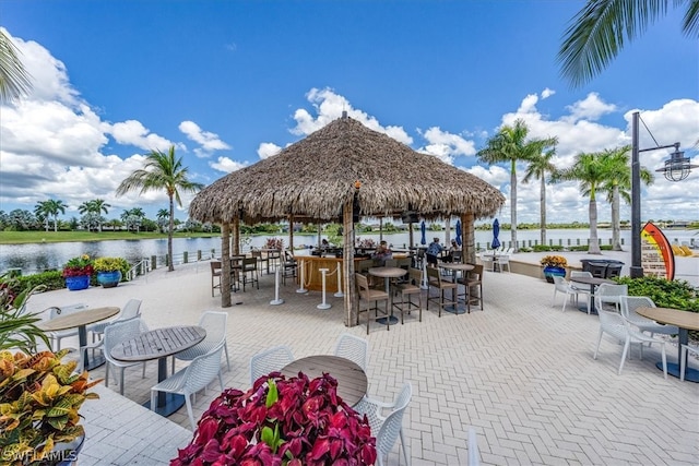 view of patio featuring a gazebo, outdoor dining area, and a water view