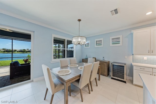 dining area featuring ornamental molding, beverage cooler, light tile patterned floors, and a chandelier