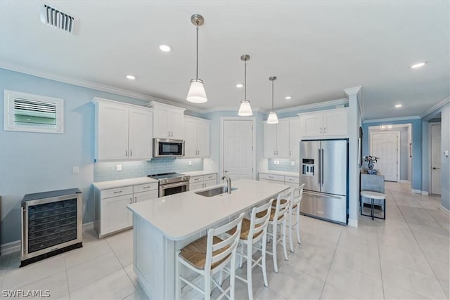 kitchen featuring light tile patterned floors, beverage cooler, visible vents, a sink, and stainless steel appliances