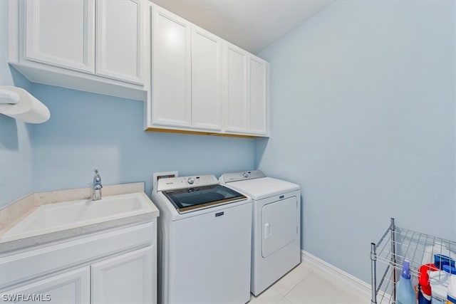 laundry room with independent washer and dryer, a sink, cabinet space, light tile patterned floors, and baseboards