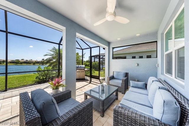 sunroom / solarium with a ceiling fan and a water view