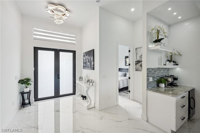 entryway with french doors and a towering ceiling