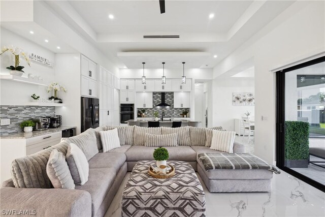 living room with a raised ceiling and sink