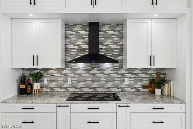 bar featuring backsplash, wall chimney range hood, white cabinets, and black electric cooktop