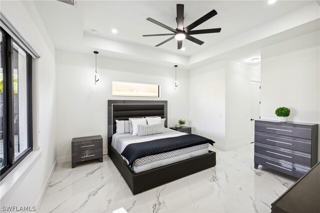 bedroom featuring ceiling fan and a raised ceiling