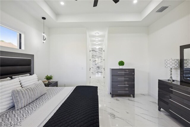 bedroom with ceiling fan and a tray ceiling