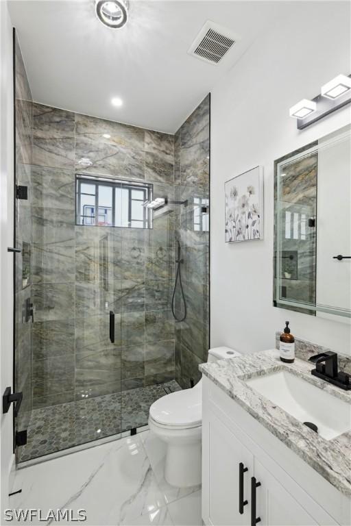 bathroom featuring an enclosed shower, vanity, and toilet