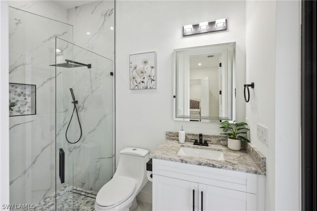 bathroom with vanity, a shower with shower door, and toilet