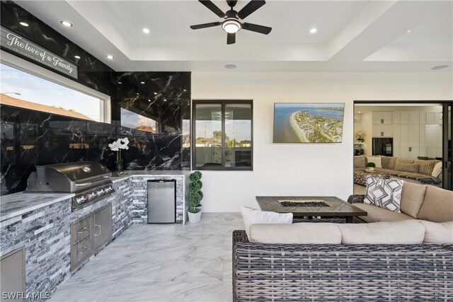 living room featuring a tray ceiling and ceiling fan