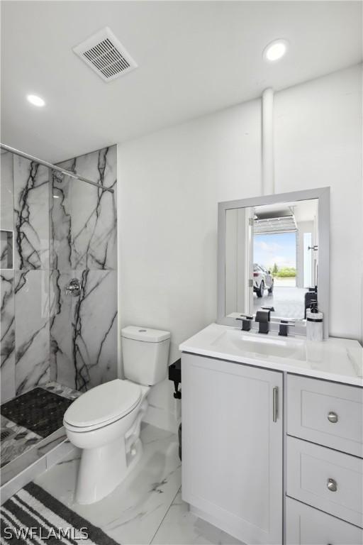 bathroom with vanity, a shower with shower door, and toilet