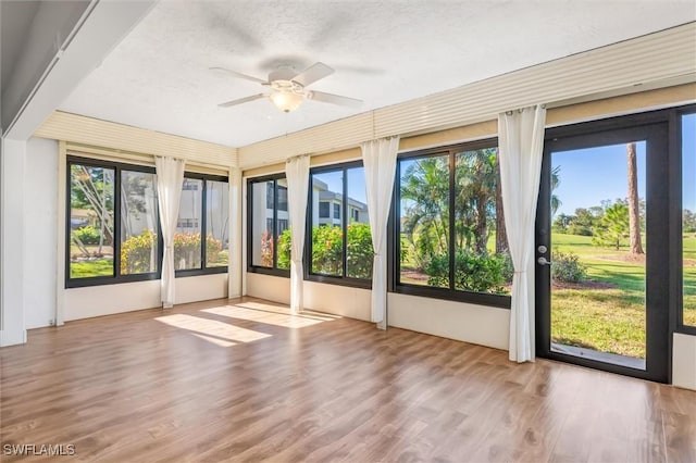 unfurnished sunroom with ceiling fan and plenty of natural light